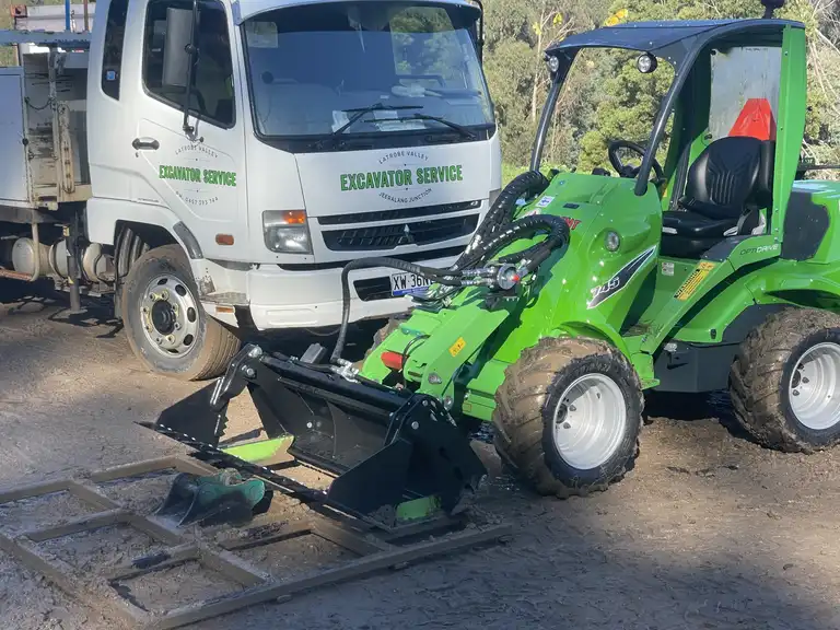 Avant loader with 4-in-1 bucket and smudge bar parked next to Latrobe Valley Excavator Service tip truck