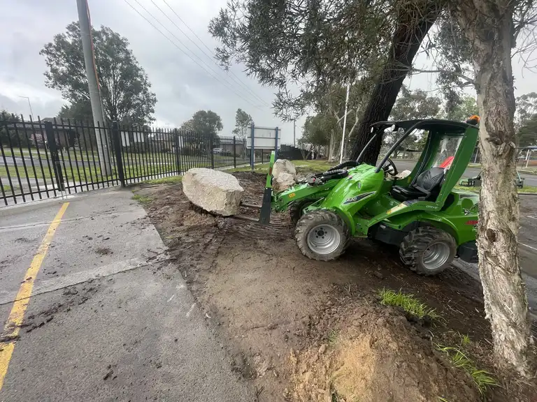 Avant loader using fork attachment to move large landscaping boulders