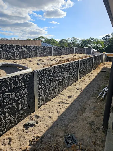 Completed block retaining wall installation in a Gippsland residential backyard