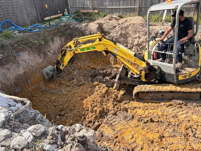 Mini excavator performing deep earthworks and site excavation