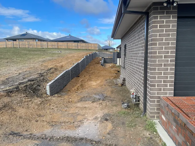 Timber retaining wall construction in progress on a residential block