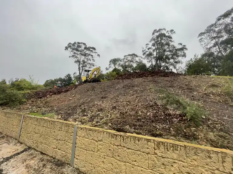 Sloped block earthworks and landscaping above a block retaining wall