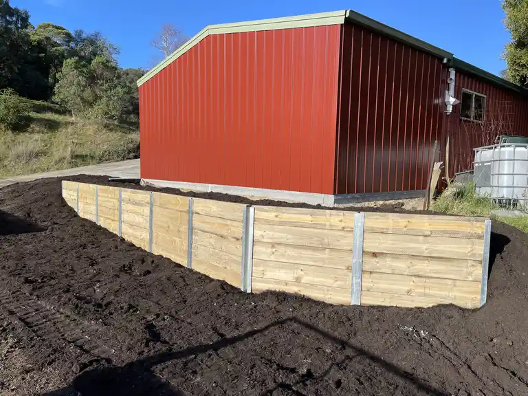 Timber sleeper retaining wall installation for a large residential shed